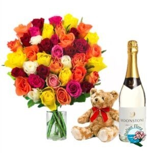 Bouquet di rose colorate con bottiglia di vino e peluche